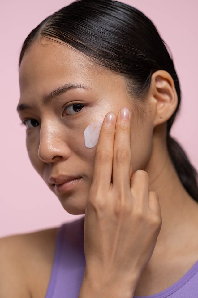 ragazza che applica la crema sul viso
